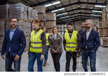 Full team of warehouse employees standing in warehouse. Team of workers, managers, female director in modern industrial factory, heavy industry, manufactrury. Full team of warehouse employees standing in warehouse. Team of workers, managers, female director in modern industrial factory, heavy industry, manufactrury. 110806952