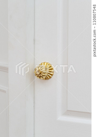 gold door knob handle. reflective surface and modern design add touch of luxury to entrance door. Crafted with metal and wood, this round knob shines with style and security. gold door knob handle. reflective surface and modern design add touch of luxury to entrance door. Crafted with metal and wood, this round knob shines with style and security. 110807548