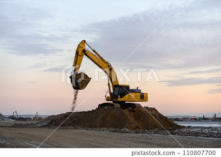 Yellow excavator working on construction site. The road construction. 110807700