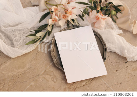 Summer wedding stationery. Birthday mock-up. Blank greeting card, invitation mockup, vintage silver plate. Apricot oleander blossoms. Olive tree branches. Beige marble background. Flat lay, top. Summer wedding stationery. Birthday mock-up. Blank greeting card, invitation mockup, vintage silver plate. Apricot oleander blossoms. Olive tree branches. Beige marble background. Flat lay, top. 110808201