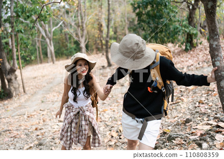 Happy LGBT Lesbian couple Travelers Hiking with Backpacks in forest Trail. LGBT Lesbian Couple Hikers with backpacks walks in mountains in vacation Happy LGBT Lesbian couple Travelers Hiking with Backpacks in forest Trail. LGBT Lesbian Couple Hikers with backpacks walks in mountains in vacation 110808359