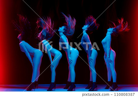Impressive performance. Young women in bodysuits dancing on high heels against black background in neon light Impressive performance. Young women in bodysuits dancing on high heels against black background in neon light 110808387