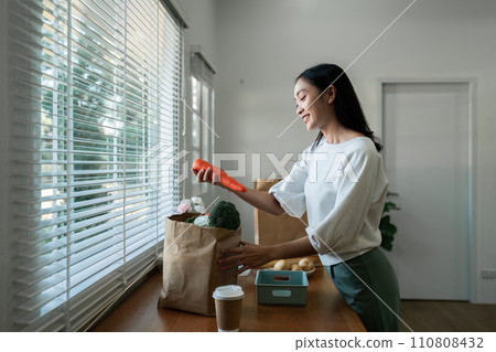 Women stay at home to prepare healthy meals, carrying trays of vegetables to prepare healthy salads at home 110808432