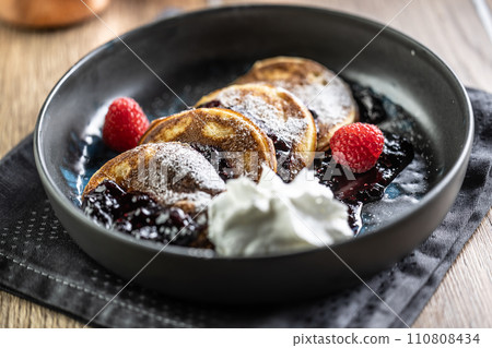 Pancakes with blueberry jam and raspberries in a bowl 110808434