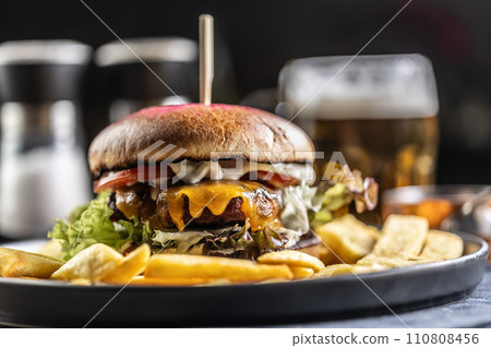 Beef burger with fries and draft beer on a pub or restaurant plate Beef burger with fries and draft beer on a pub or restaurant plate 110808456