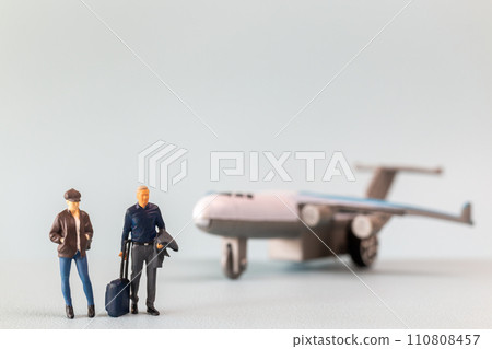 Miniature people, travelers embarks on a delightful vacation, gleefully boarding a tiny airplane Miniature people, travelers embarks on a delightful vacation, gleefully boarding a tiny airplane 110808457