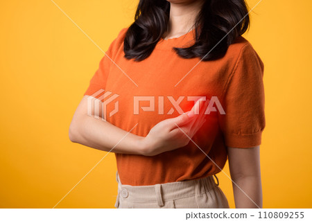Empower breast health on World Health Day, woman's breast cancer check on a bright yellow background. Empower breast health on World Health Day, woman's breast cancer check on a bright yellow background. 110809255