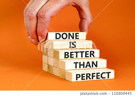 Done is better than perfect symbol. Concept words Done is better than perfect on wooden blocks. Beautiful orange background. Businessman hand. Business, done is better than perfect concept. Copy space Done is better than perfect symbol. Concept words Done is better than perfect on wooden blocks. Beautiful orange background. Businessman hand. Business, done is better than perfect concept. Copy space 110809445