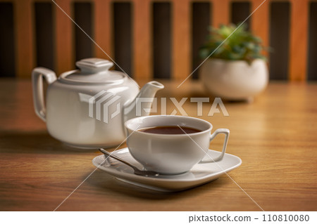 Herbal tea with white tea cup and teapot 110810080