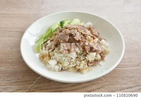 fried salty slice beef meat with garlic and pepper on rice in plate 110810690
