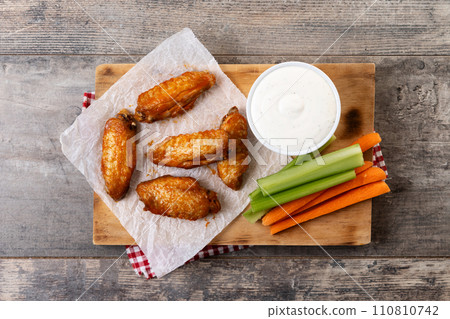 Buffalo spicy chicken wings with cayenne pepper sauce on wooden table Buffalo spicy chicken wings with cayenne pepper sauce on wooden table 110810742