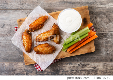 Buffalo spicy chicken wings with cayenne pepper sauce on wooden table 110810749