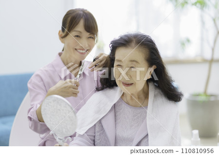 Senior woman receiving haircut at home Senior woman receiving haircut at home 110810956