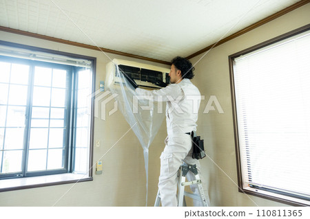 Male worker cleaning the air conditioner 110811365