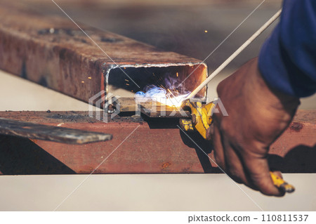 Men hands wear protective glove Hot flame metal work cutting fire iron workshop. Locksmith use Welding machine cut metal process. Construction Worker hands using Welding machinery iron metal sparking 110811537