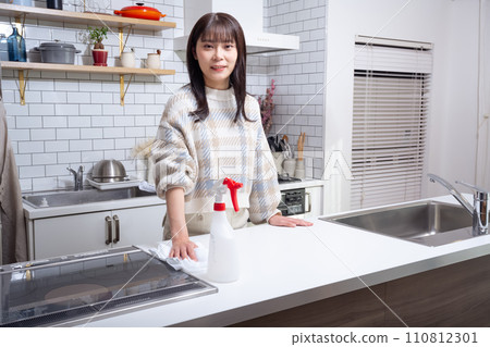 A woman cleaning in the kitchen A woman cleaning in the kitchen 110812301