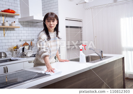 A woman cleaning in the kitchen A woman cleaning in the kitchen 110812303