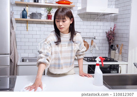 A woman cleaning in the kitchen 110812307