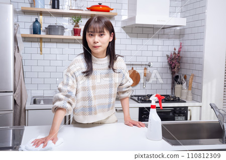 A woman cleaning in the kitchen 110812309