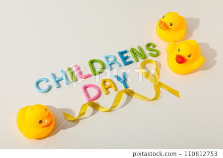 The inscription Children's Day with a yellow ribbon and a toy duck 110812753