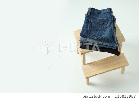 Ukraine, Kyiv, 28.10.2023 Folded jeans on a wooden chair 110812998