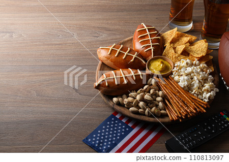 A bowl with various snacks, a remote control and an American flag 110813097
