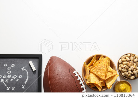 Popcorn and chips with a rugby ball on a light background Popcorn and chips with a rugby ball on a light background 110813364