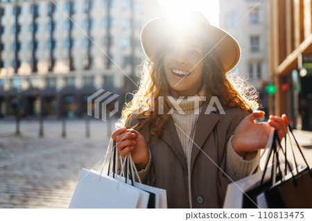 Woman in shopping. Young Girl with colorful shopping bags walking around the city after shopping. 110813475