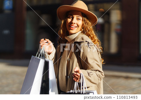 Woman in shopping. Young Girl with colorful shopping bags walking around the city after shopping. 110813493