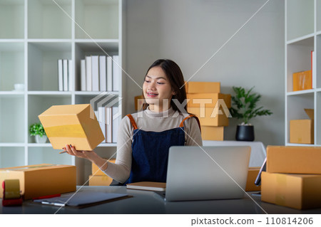 Woman use scotch tape to attach parcel box to prepare goods for the process of packaging, shipping, online sale internet marketing ecommerce concept startup business idea 110814206