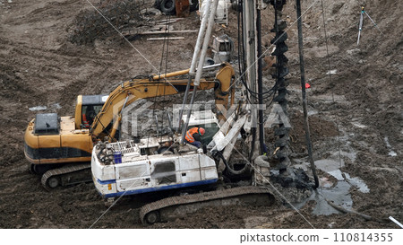 Kiev, Ukraine, October 17, 2018: Workers in the mud of a construction site at the stage of excavation; construction of a supermarket AUCHAN Kiev, Ukraine, October 17, 2018: Workers in the mud of a construction site at the stage of excavation; construction of a supermarket AUCHAN 110814355
