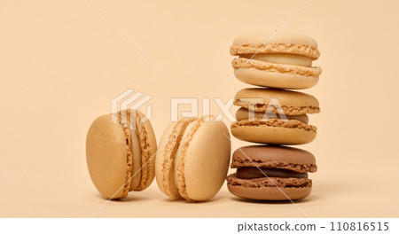 Chocolate macarons on a beige background, a stack of dessert 110816515
