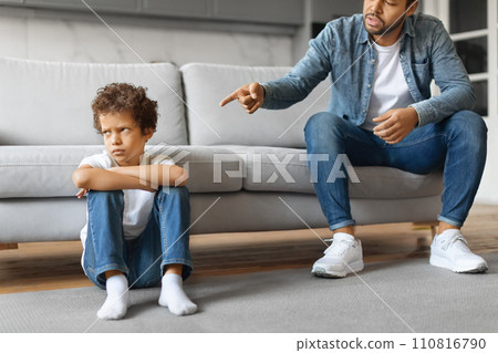 Angry african american father scolding upset little son at home Angry african american father scolding upset little son at home 110816790