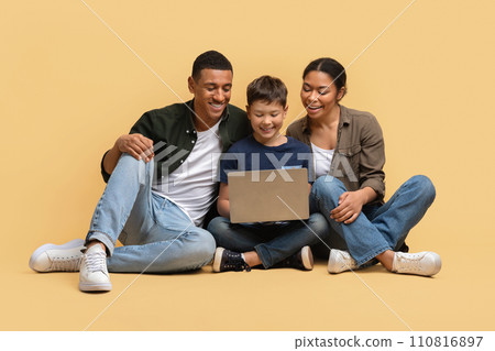 Beautiful family watching movie together, using laptop Beautiful family watching movie together, using laptop 110816897