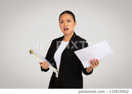 Concerned Asian businesswoman holding a clipboard and a document 110816902