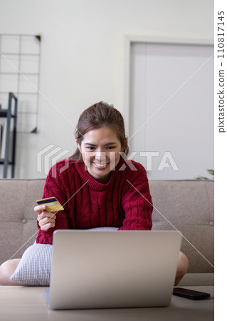 Young Asian woman hands holding credit card and using laptop for internet purchase. Online shopping, Online payment at home 110817145