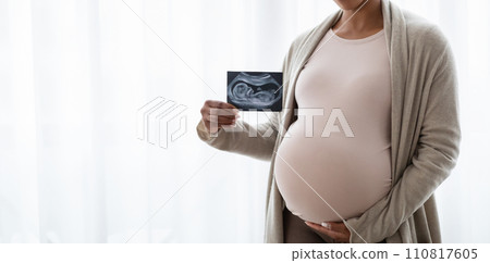 Cropped of young pregnant black woman showing baby sonogram Cropped of young pregnant black woman showing baby sonogram 110817605