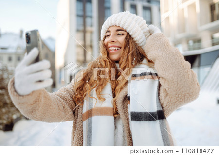 Young woman taking selfie in winter street. Holidays, rest, blogging. Young woman taking selfie in winter street. Holidays, rest, blogging. 110818477