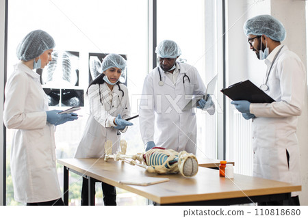 Middle aged Indian female doctor, anatomy teacher, explaining bones anatomy 110818680