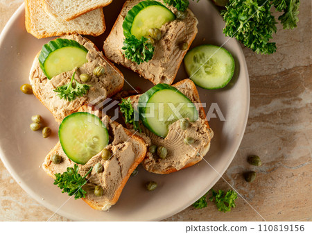 Open sandwiches with pate, cucumber, capers, and parsley. Open sandwiches with pate, cucumber, capers, and parsley. 110819156