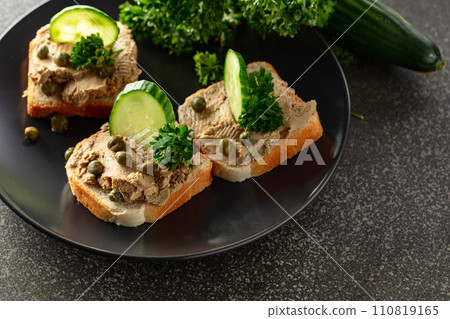 Open sandwiches with pate, fresh cucumber, capers, and parsley. 110819165