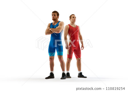 Two young confident and focused men in blue and red sportwear posing against white studio background. 110819254