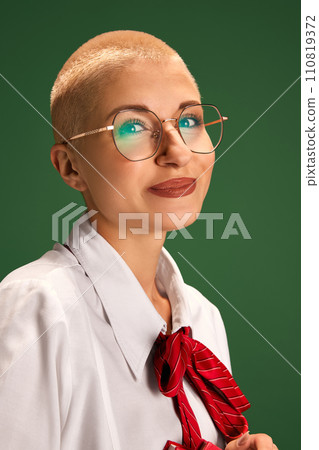 Portrait of young, attractive, successful woman in glasses looking at camera against green studio background. Portrait of young, attractive, successful woman in glasses looking at camera against green studio background. 110819372