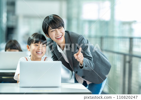 A girl and her teacher studying programming. A girl and her teacher studying programming. 110820247