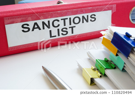 Folder with a label sanctions list and a stack of documents. Folder with a label sanctions list and a stack of documents. 110820494