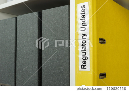 Folder with label regulatory updates on the shelf. 110820538