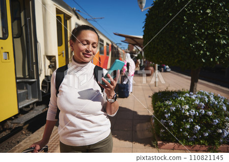 Caucasian tourist commuter woman at train station, using smartphone map, social media check-in, or buy ticket booking. 110821145