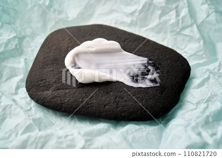 A smear of white cream on a black stone. A smear of white cream on a black stone. 110821720