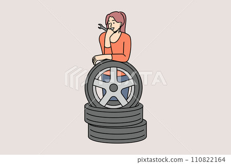 Woman auto mechanic prepares to replace car wheels during vehicle maintenance or repair 110822164