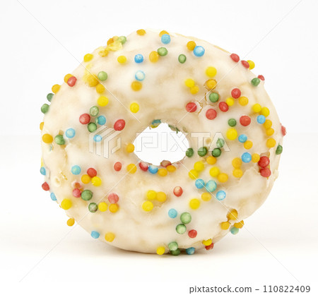 White chocolate doughnut topped with colored sprinkles. 110822409